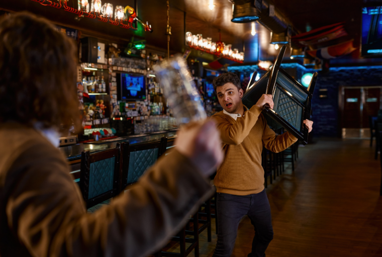 Image is of a man holding a chair over his head about to swing it at someone els who is holding a beer bottle, concept of public disorderly conduct in South Carolina