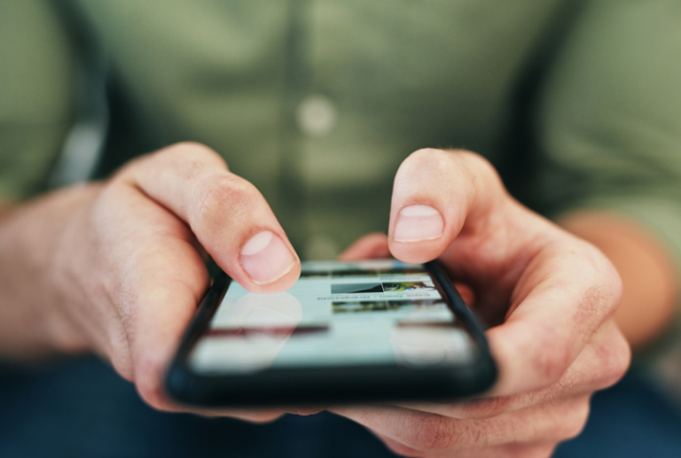 Image is of a closeup of a person holding a cellphone while on social media, concept of social media and personal injury cases