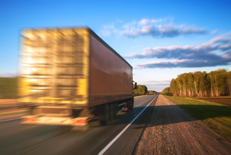 Image is of a speeding truck on a highway, concept of differences between truck accidents and car accidents