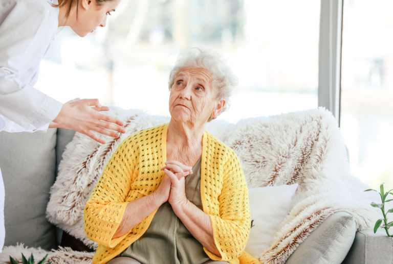 Image is of an elderly woman being scolded by a caretaker at a facility, concept of nursing home abuse