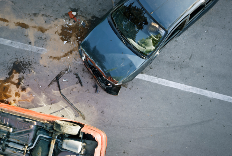 Image is from an aerial view of a car accident with one of the cars having been flipped over, concept of do you need a car accident lawyer?