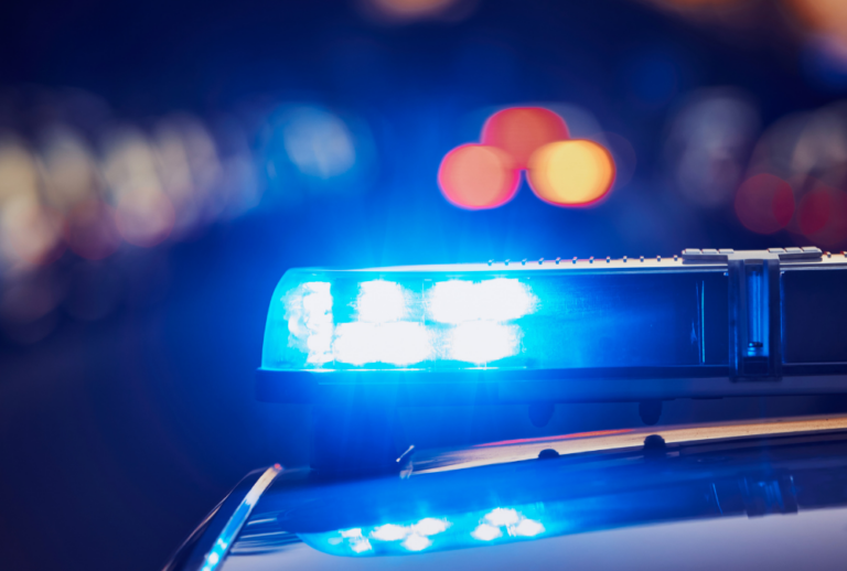Image is of a closeup of police car lights at night, concept of knowing your rights and police conduct