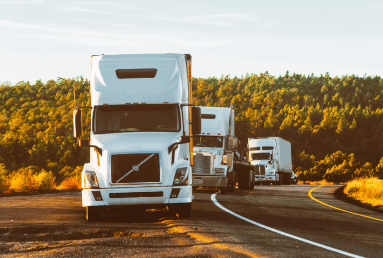 Image is of three semi trucks, one behind the other, on the side of the road, concept of who is liable in a truck accident in South Carolina