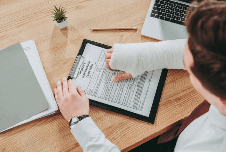 Image is of an injured man with his arm in a cast and filling out a workers' compensation form, concept of personal injury claim and workers' compensation in Aiken
