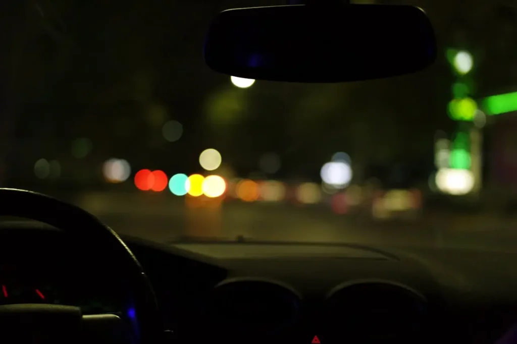 Blurred night driving view from inside a car, showing impaired visibility often linked with DUI risks.