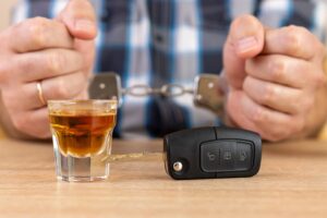 andcuffed driver with car key and alcohol symbolizing DUI convictions and South Carolina law