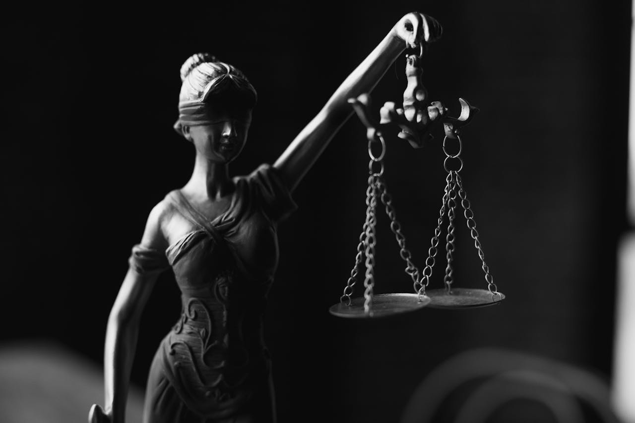 lack and white statue of Lady Justice holding scales.
