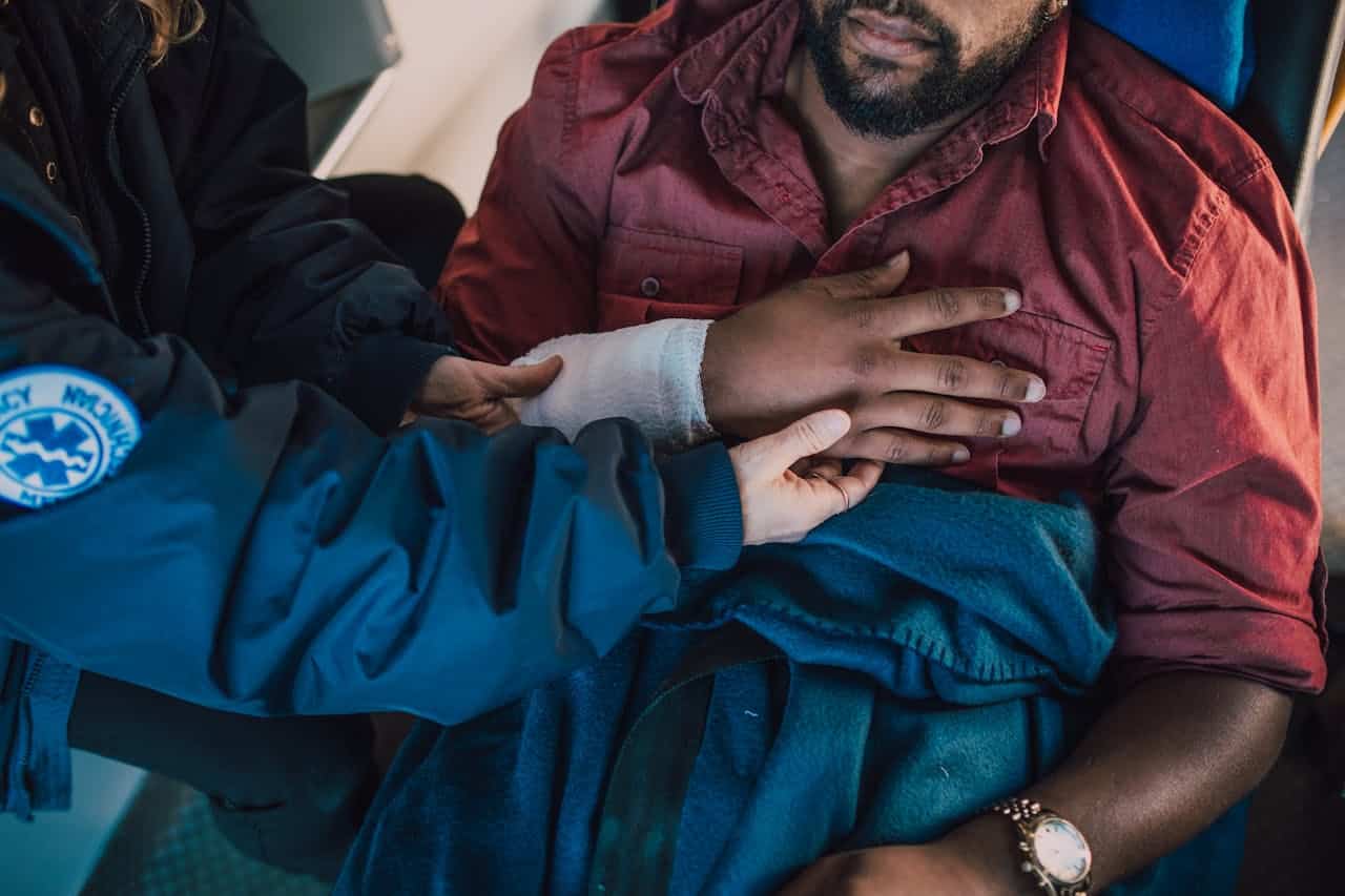 Paramedic treating injured man’s arm after a bike accident.
