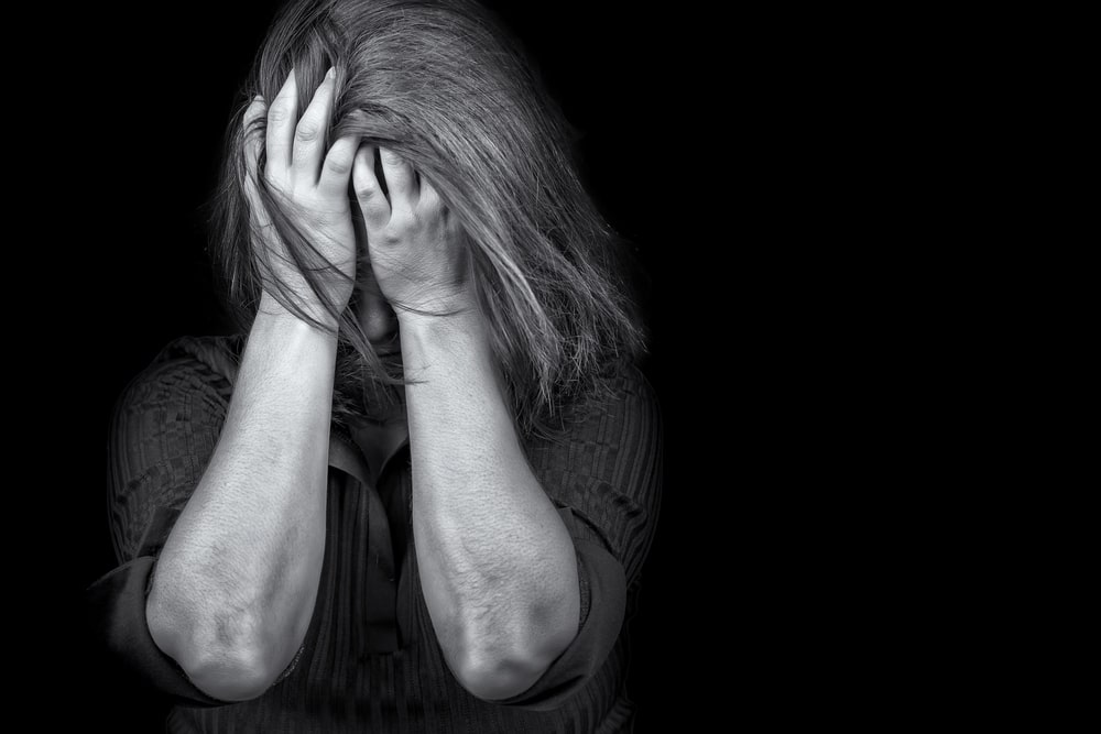 Image shows an individual experiencing emotional distress, illustrating the serious personal impact of domestic violence offenses and related legal penalties.