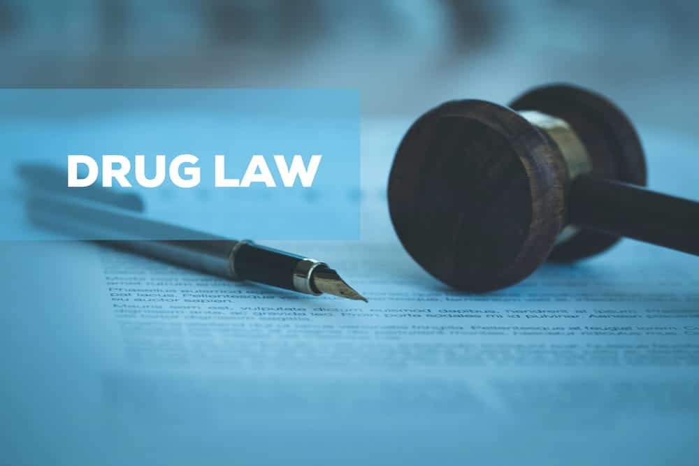 Image is of a judge gavel beside legal paperwork, concept of drug charges and college student legal consequences