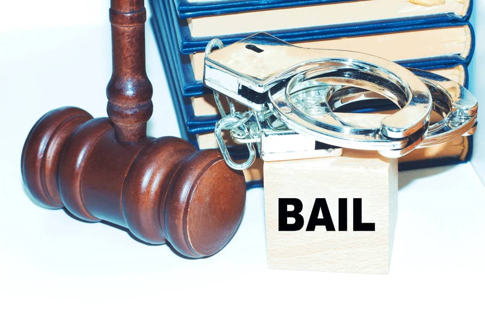 Image is of a judge gavel beside handcuffs and a bail block, representing consequences of missing DUI court in Aiken and court imposed restrictions.