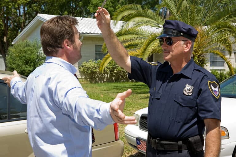 Image is of a police officer conducting a roadside balance check on a driver during field sobriety tests in Aiken, concept of DUI investigation and refusal rights.