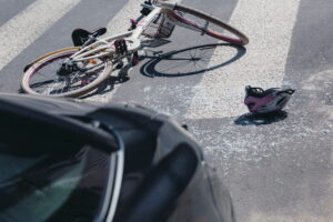 Image is of a damaged bicycle and helmet on the road after a collision, representing a bicycle accident claim following a crash in South Carolina.