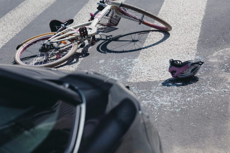 Image is of a damaged bicycle and helmet on the road after a collision, representing a bicycle accident claim following a crash in South Carolina.