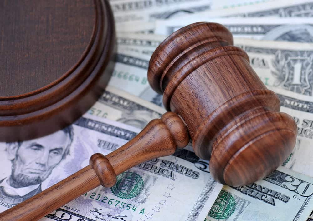 Image is of a judge’s gavel placed on U.S. dollar bills, representing financial considerations and bail decisions during a DUI bond hearing