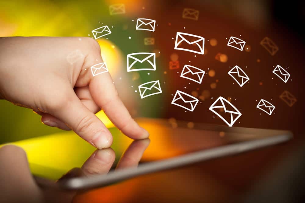 Image is of a hand interacting with a tablet as message icons appear, illustrating how text messages may be examined in DV cases in Aiken