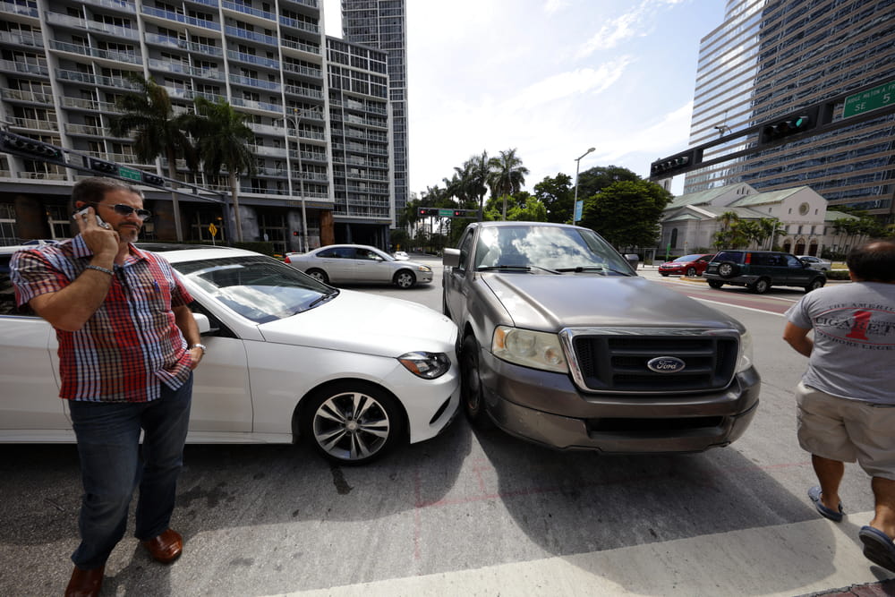 Image is of a car accident at an intersection with drivers present, showing fault assessment in an Aiken car accident