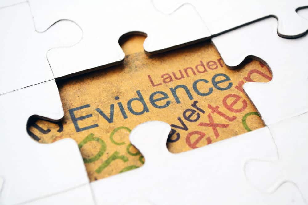 Image is of a puzzle piece revealing the word evidence, symbolizing how different elements come together in DV cases in Aiken
