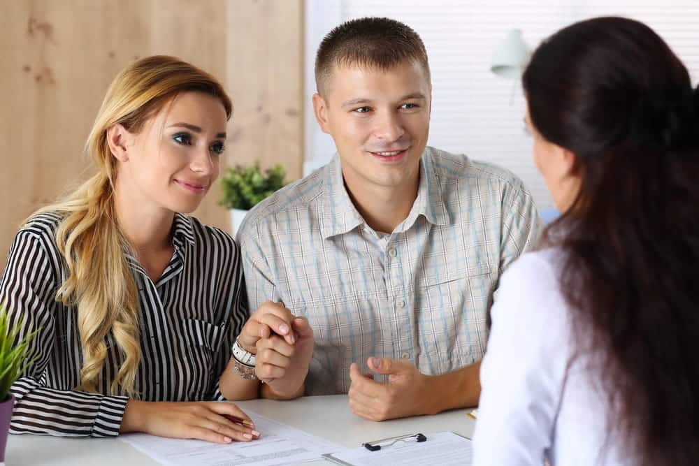 Image is of a couple meeting with a professional during a consultation, concept of an Aiken adoption lawyer assisting prospective parents with adoption planning and legal requirements.