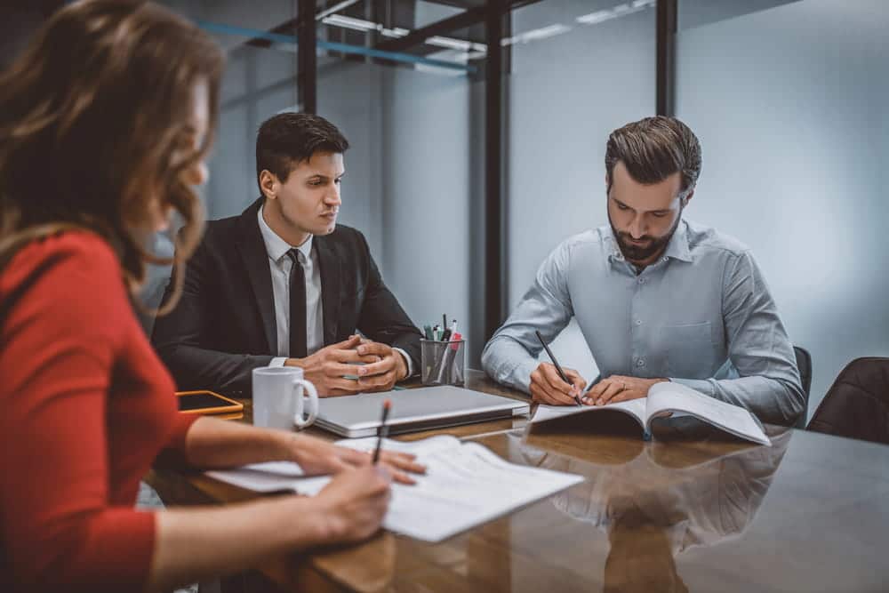 Image is of a client meeting with legal professionals to review financial matters and support obligations, concept of an alimony lawyer.