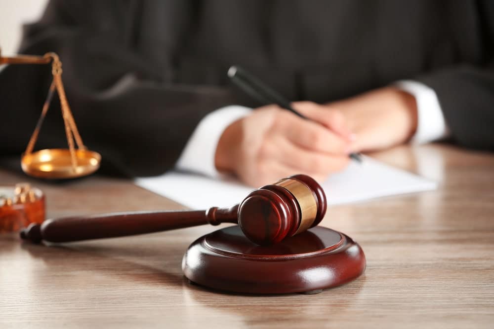 Image is of a judge's gavel and legal documents on a desk representing court proceedings and support disputes, concept of an alimony lawyer.