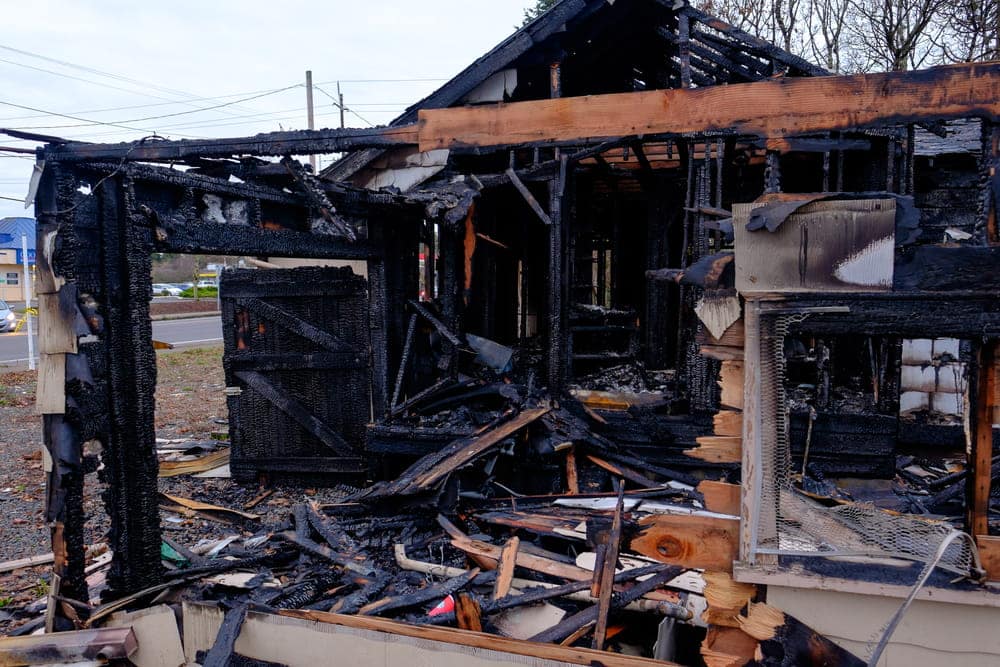 Image is of a heavily damaged structure after a fire, concept of an Aiken arson lawyer handling cases involving fire scene investigations and property damage.
