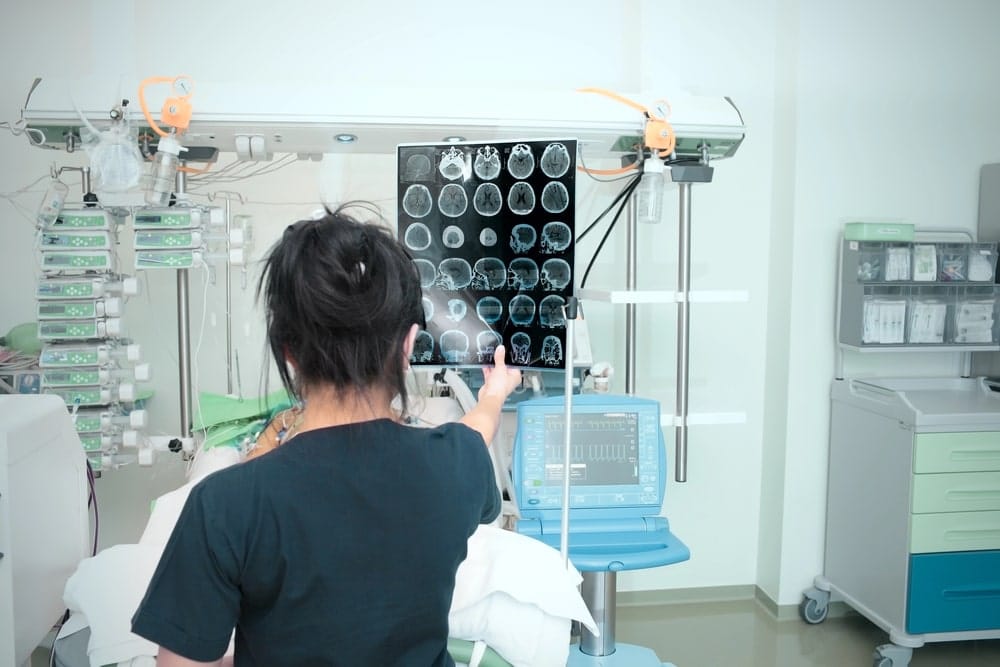 Image is of a medical professional reviewing brain scan images in a hospital setting, concept of an Aiken brain injury lawyer helping document traumatic brain injuries.