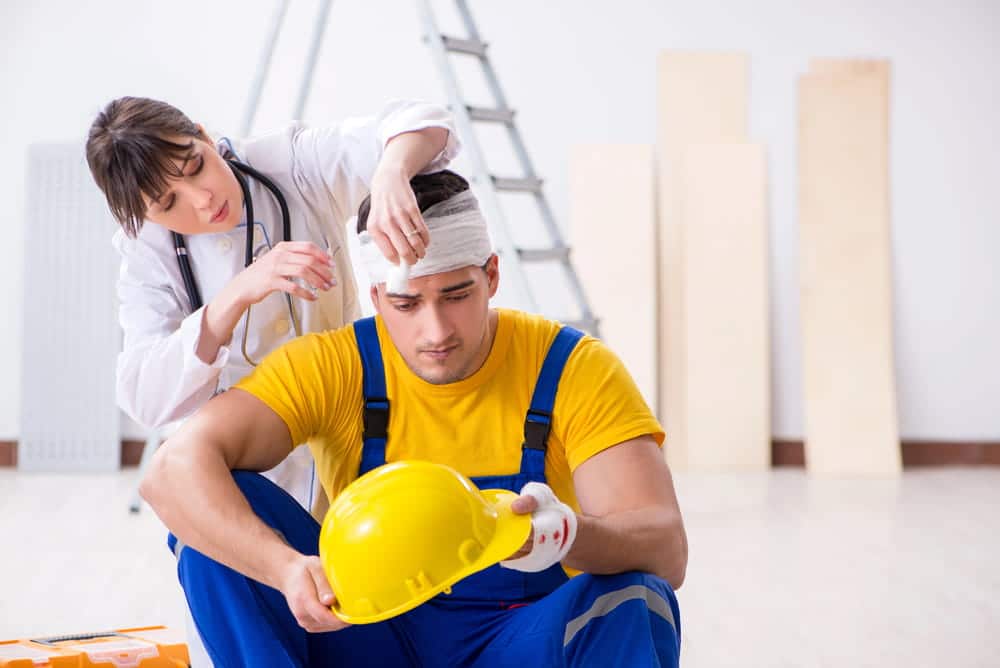 Image is of an injured construction worker receiving medical attention after a head injury, concept of an Aiken brain injury lawyer assisting accident victims.