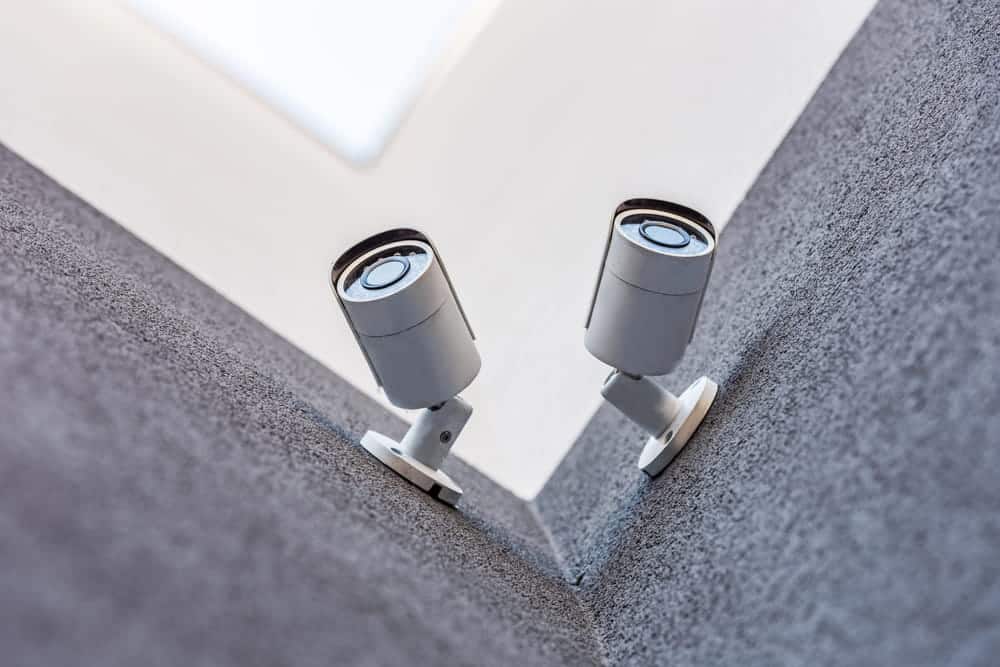 Image is of security cameras mounted on a building, concept of an Aiken burglary lawyer reviewing surveillance evidence in a criminal investigation.