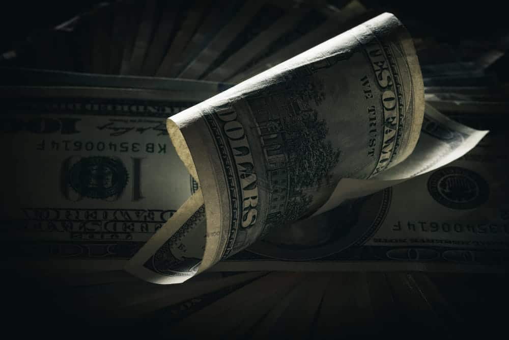 Image is of rolled U.S. currency representing financial recovery, concept of an Aiken catastrophic injury lawyer seeking compensation for serious long-term injuries.