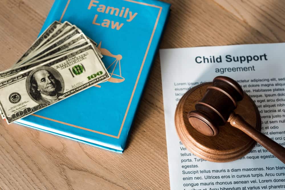 Alt Text: Image is of a child support agreement, family law materials, and a judge's gavel, concept of legal matters handled by a child support lawyer in Aiken.