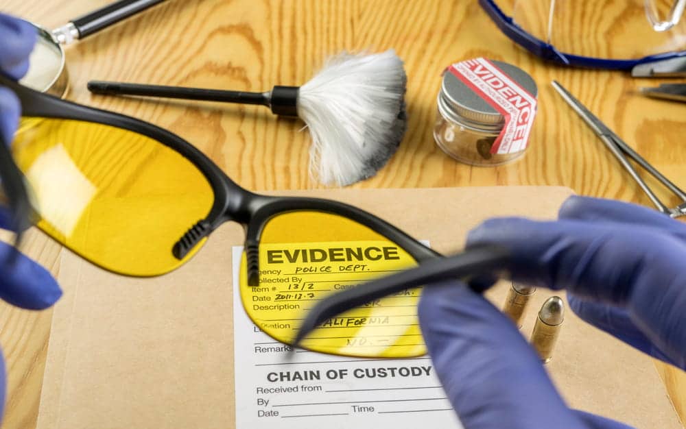 Image is of investigators examining evidence and chain-of-custody materials, concept of an Aiken drug crimes lawyer evaluating evidence collection procedures in a criminal case.