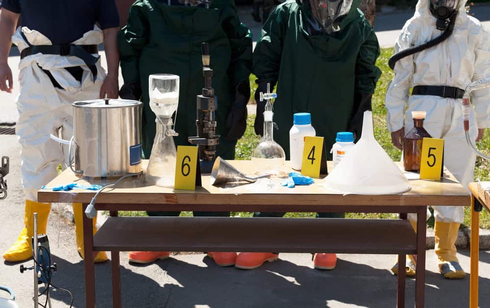 Image is of laboratory equipment and evidence markers at a suspected drug manufacturing scene, concept of an Aiken drug manufacturing lawyer analyzing forensic evidence used by prosecutors.