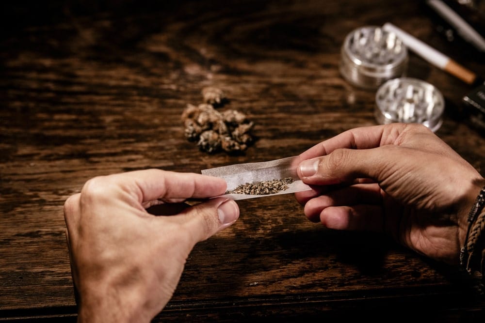 Image is of an individual handling a substance on a table, concept of an Aiken drug trafficking lawyer examining evidence related to alleged drug trafficking offenses.