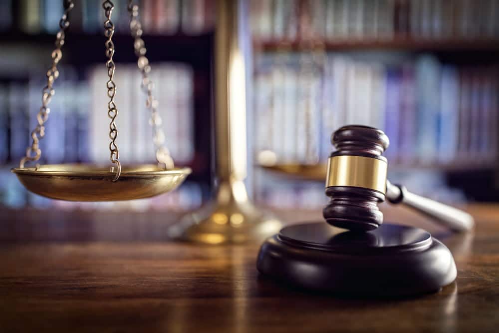 Image is of a judge's gavel and scales of justice on a courtroom desk, concept of an Aiken embezzlement lawyer representing clients facing financial crime allegations.