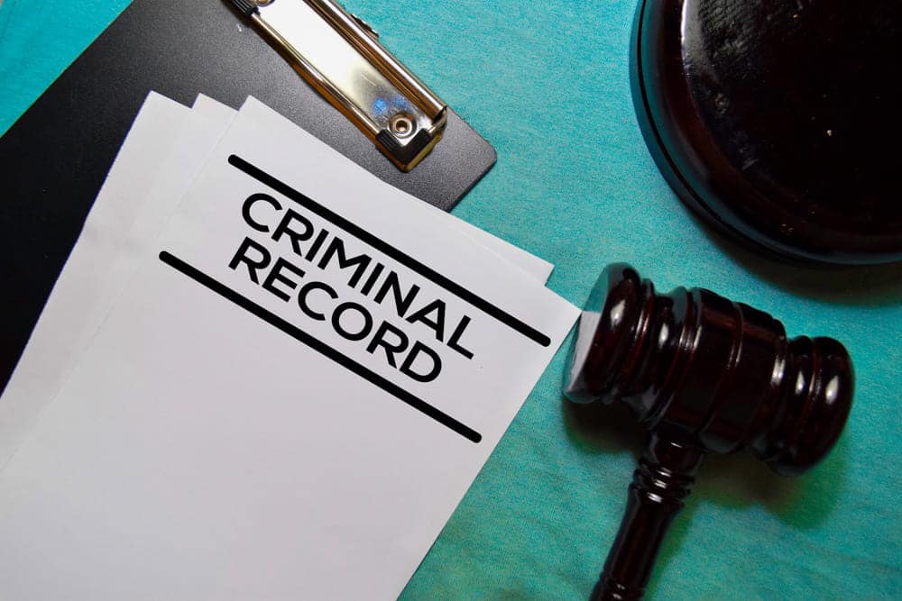 Image is of criminal record documents displayed beside a judge's gavel, concept of an Aiken expungement lawyer evaluating records for potential expungement.