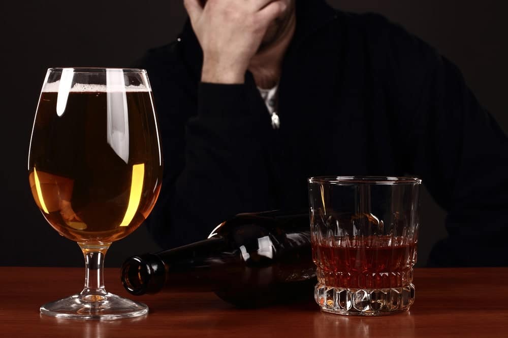 Image is of a person seated with alcoholic beverages on a table, concept of a felony DUI lawyer addressing allegations involving impaired driving.