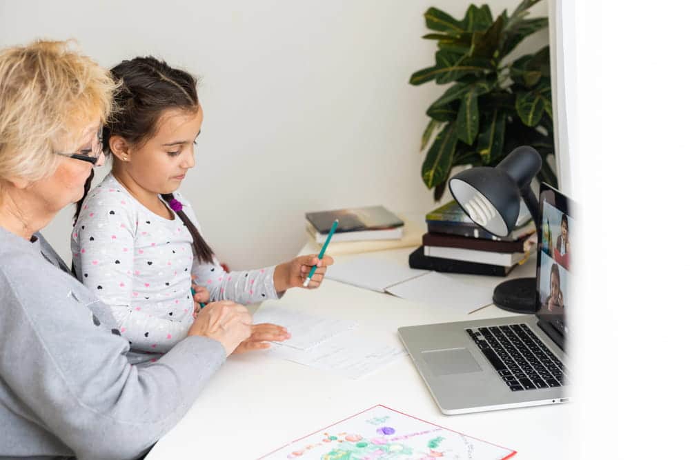 Image is of a grandparent helping a child with schoolwork, concept of an Aiken grandparents' rights lawyer supporting grandparent visitation and family relationships.