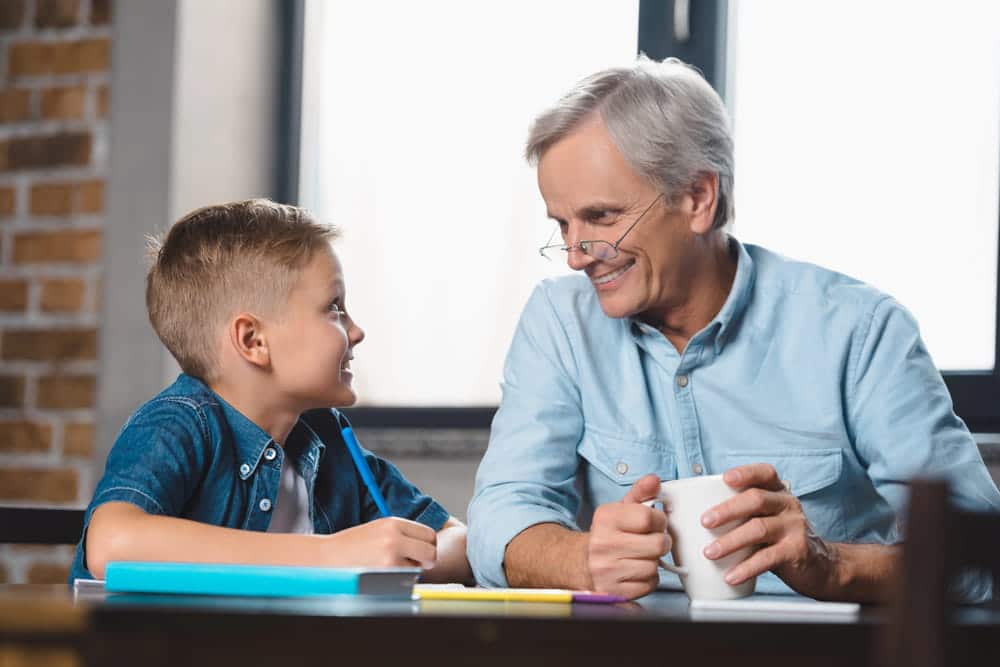 Image is of a grandparent and grandchild spending quality time together at a table, concept of an Aiken grandparents' rights lawyer protecting meaningful family bonds.