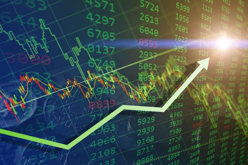 Image is of financial charts and stock market data displayed over investment documents, concept of an Aiken insider trading lawyer reviewing securities trading evidence.