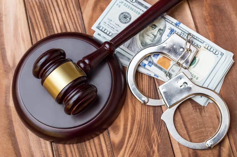 Image is of a judge's gavel, handcuffs, and U.S. currency, concept of an Aiken kidnapping lawyer defending clients facing serious felony charges.