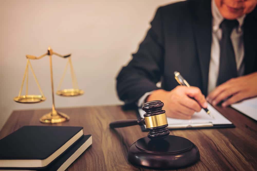 Image is of a legal professional preparing documents near a gavel and scales of justice, concept of a legal separation lawyer.
