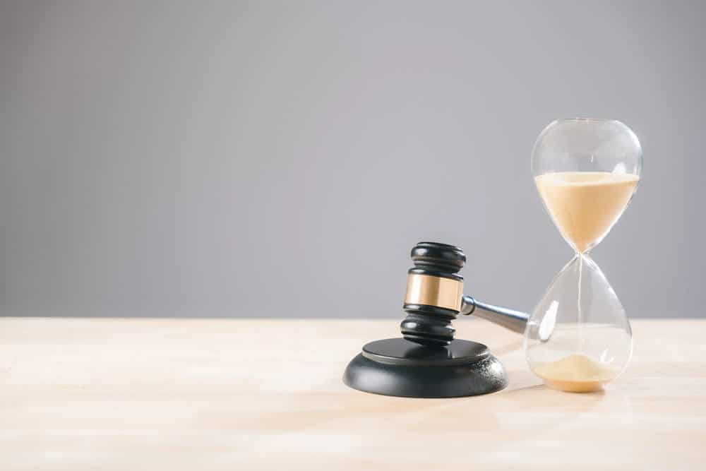 Image is of a judge's gavel beside an hourglass, concept of an Aiken medical malpractice lawyer helping clients understand legal deadlines for filing claims.