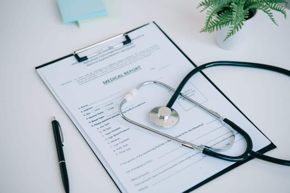 Image is of medical records and a stethoscope on a desk, concept of a motorcycle accident lawyer reviewing injury documentation and treatment records.
