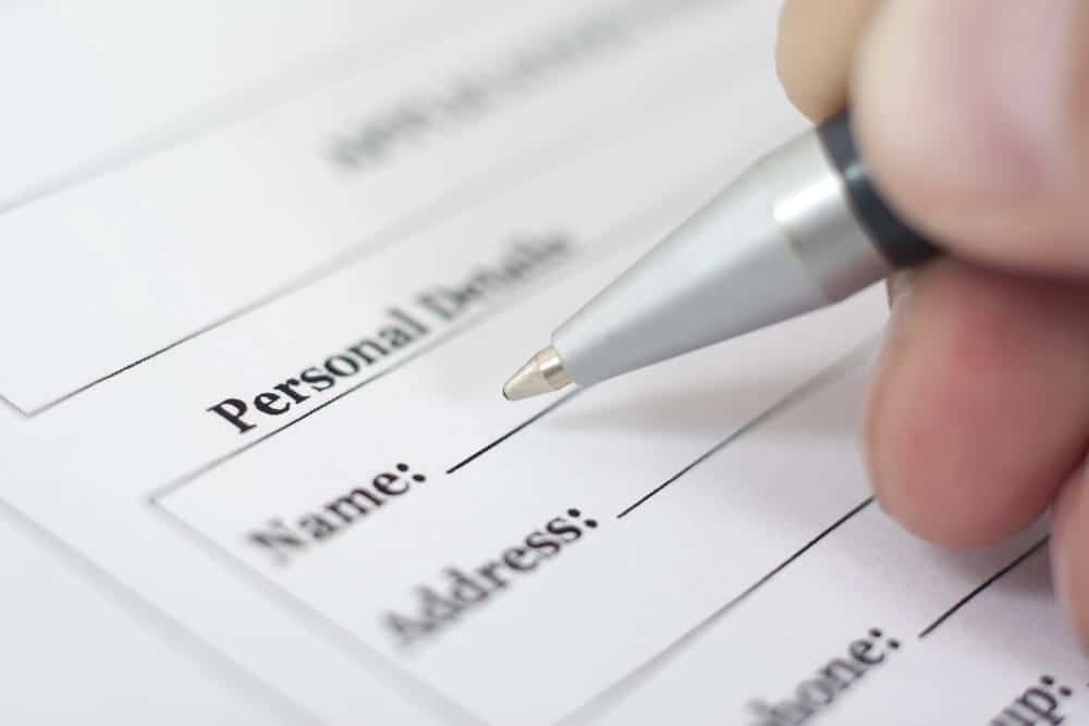 Image is of a pen completing a personal information form, concept of an Aiken name change lawyer assisting with legal paperwork required for a name change request.