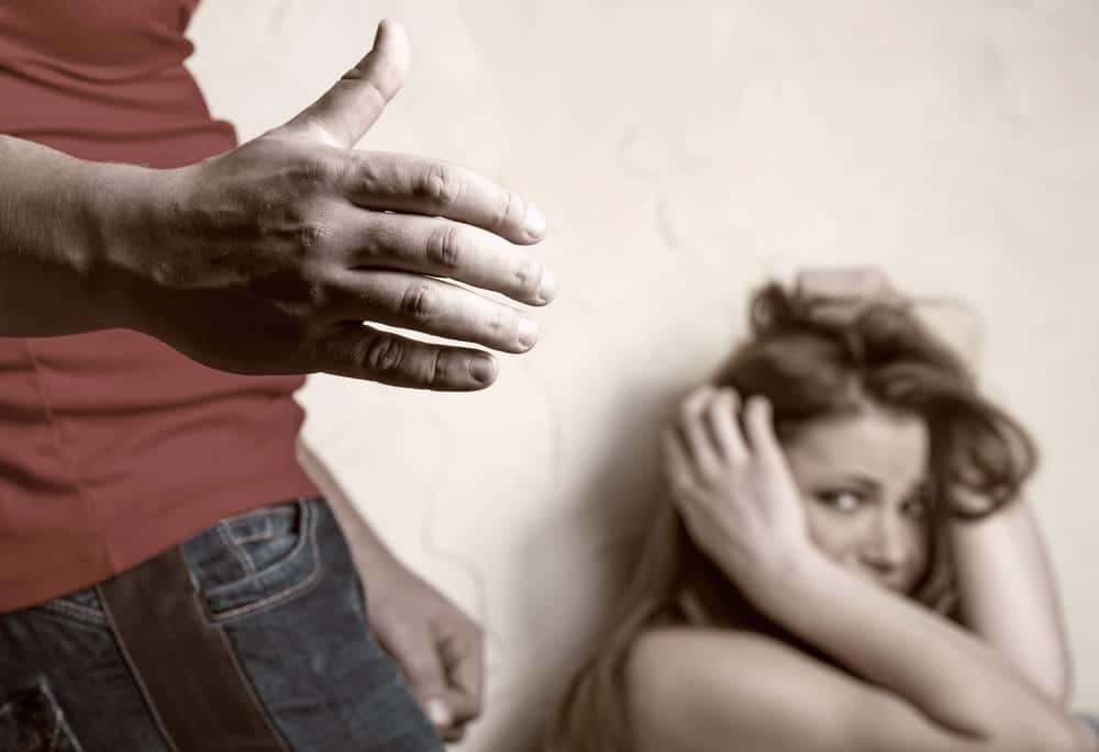 Image is of a distressed woman with a person standing nearby, concept of an Aiken order of protection lawyer assisting individuals seeking legal protection from alleged domestic abuse or threats.
