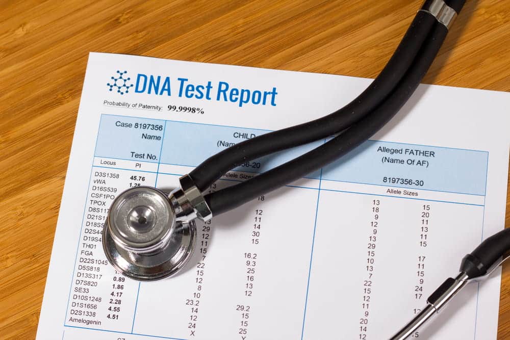 Image is of a DNA test report with medical equipment placed on top, concept of an Aiken paternity lawyer assisting with legal parentage and paternity testing matters.
