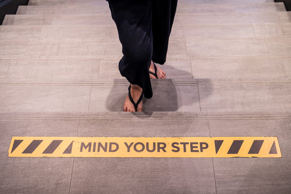 Image is of a warning strip marking a change in floor level, concept of a premises liability lawyer handling claims involving dangerous walking surfaces.