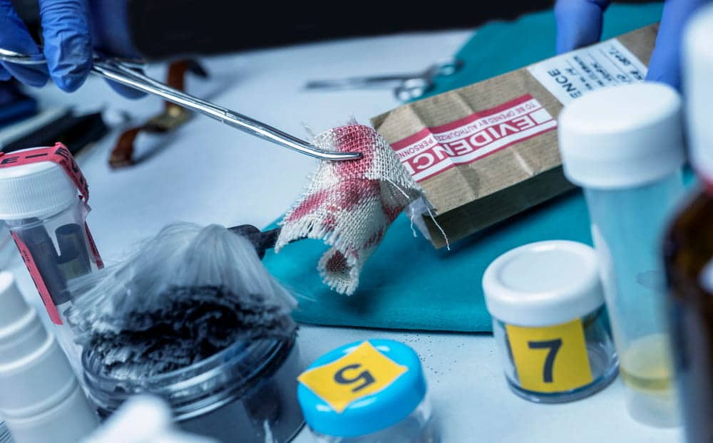 Image is of forensic investigators collecting and examining evidence during a criminal investigation, concept of an Aiken rape lawyer reviewing evidence in a criminal defense case.