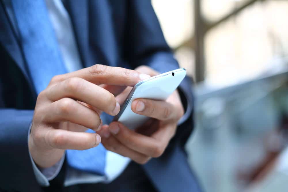 Image is of an individual using a smartphone, concept of an Aiken sex crimes lawyer reviewing digital communications and electronic evidence.